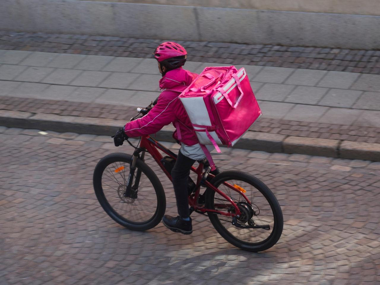 A person delivering food on a bicycle.