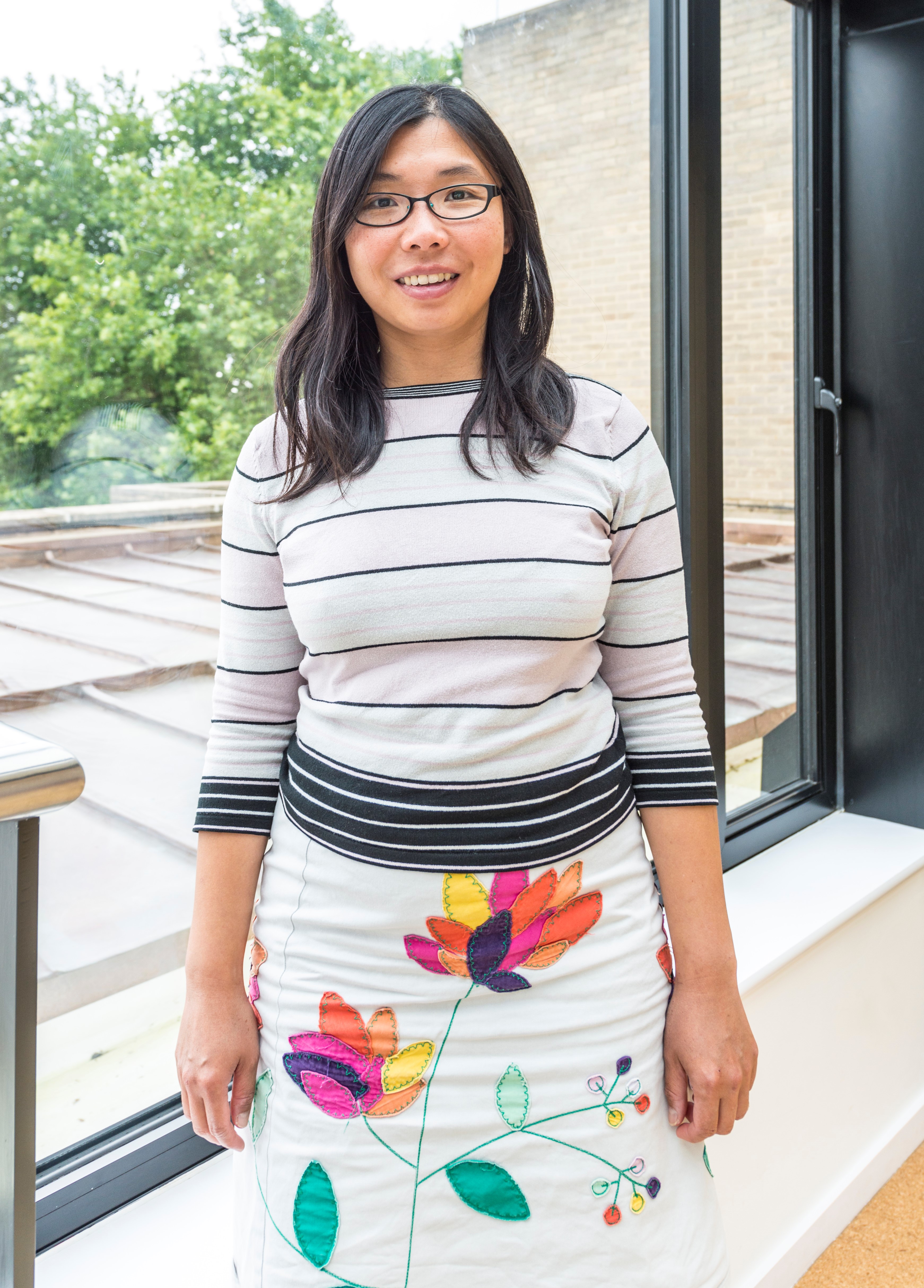 Woman in coloured clothes smiling at the camera
