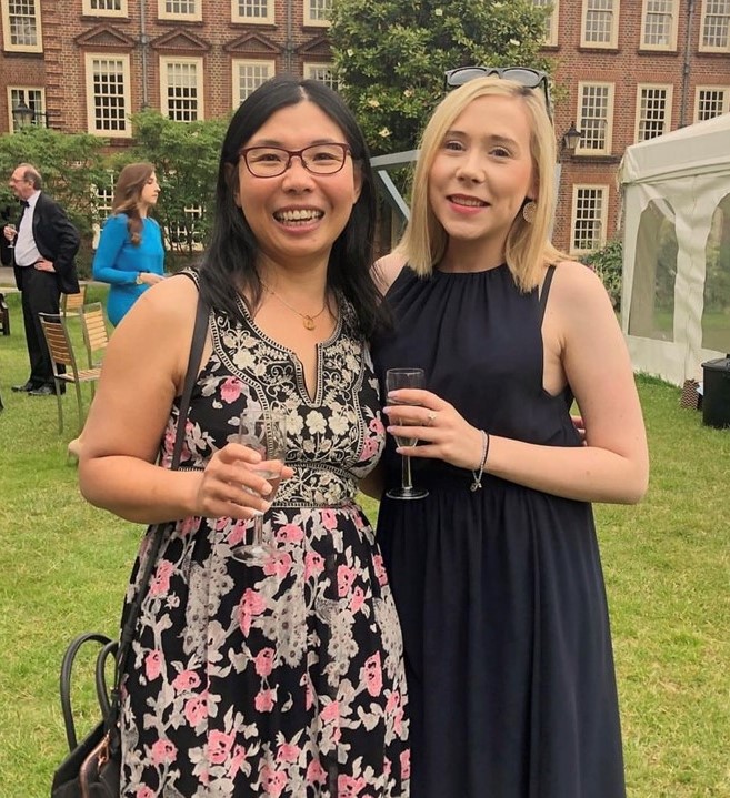 Two women smiling with drinks in their hands
