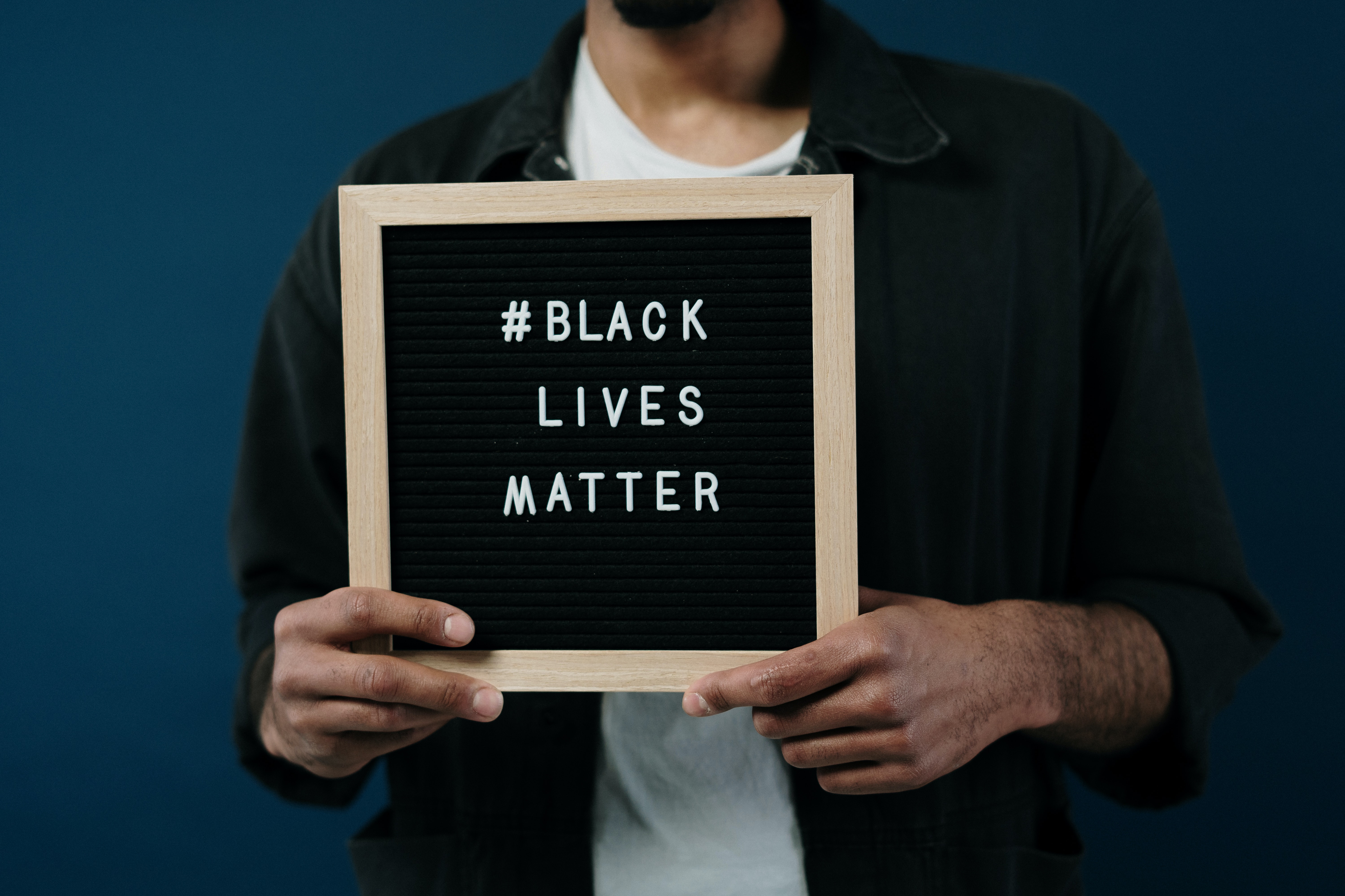 man holding sign that reads 'black lives matter'