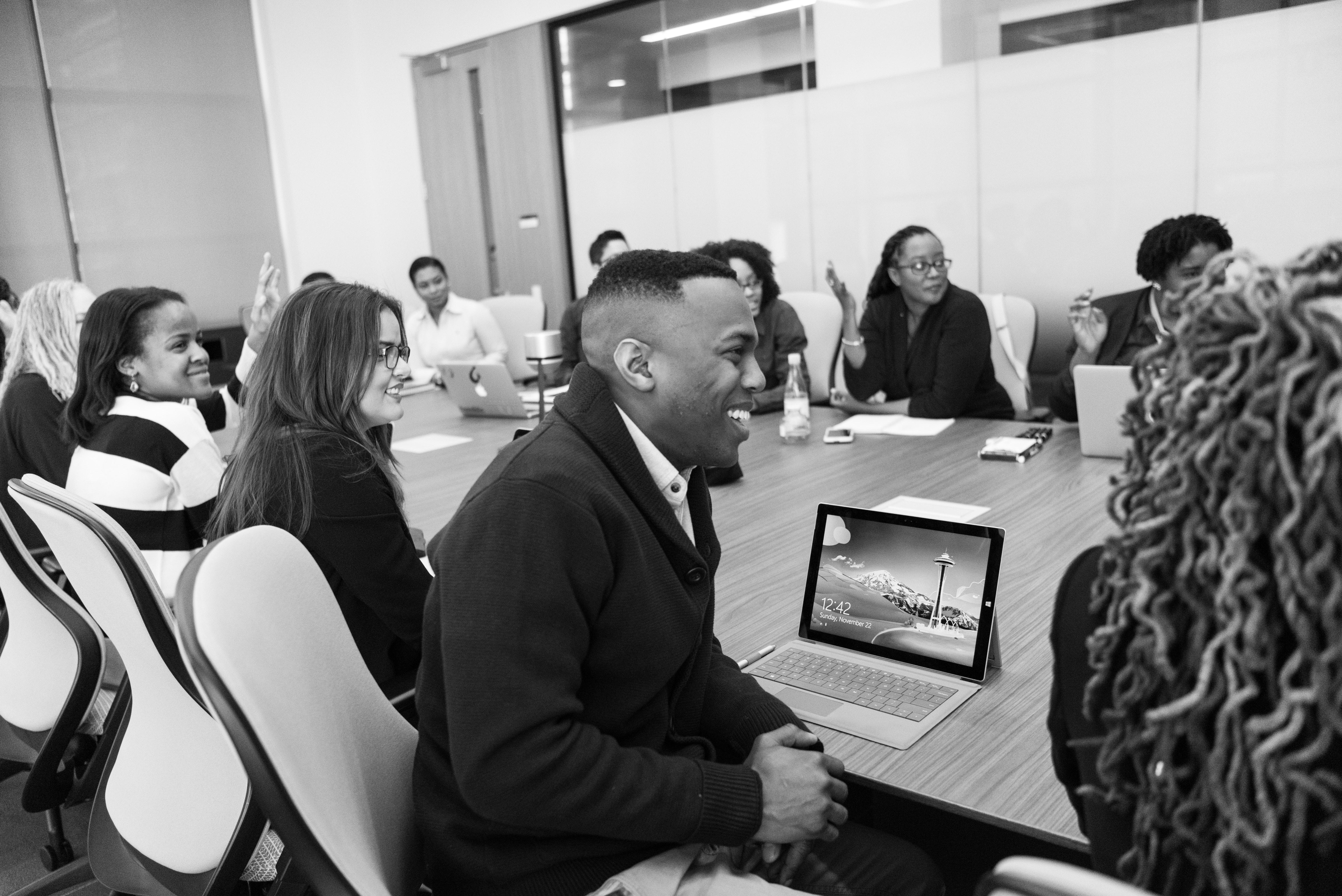 A black and white photo of people in a meeting.