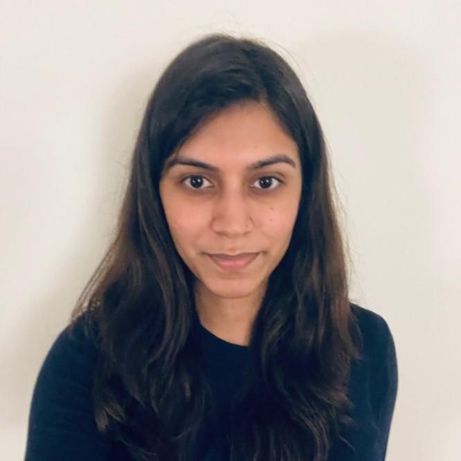 Aditi Khemani dressed in Black smiling at the camera