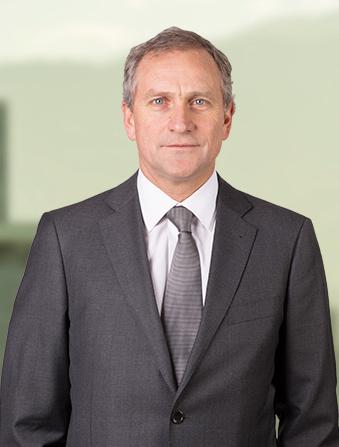 A photo of Juan dressed formally in a grey blazer and a grey tie.