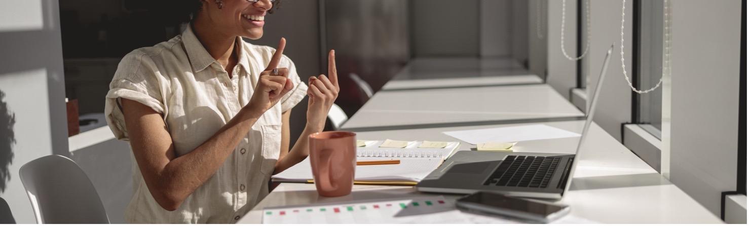 A woman signing in front of a computer.