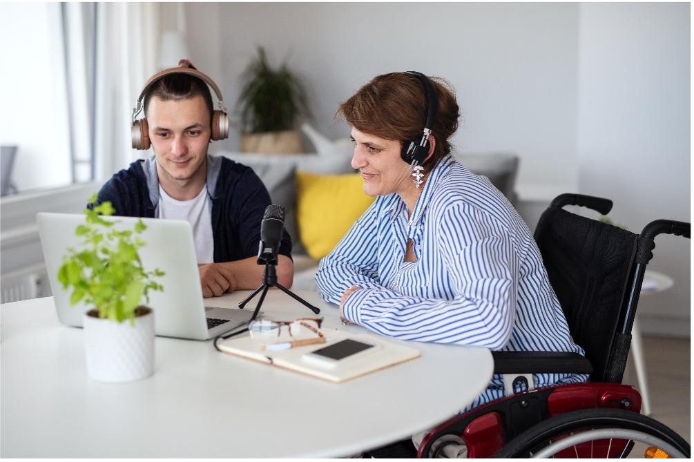 Two people at a table recording a podcast.