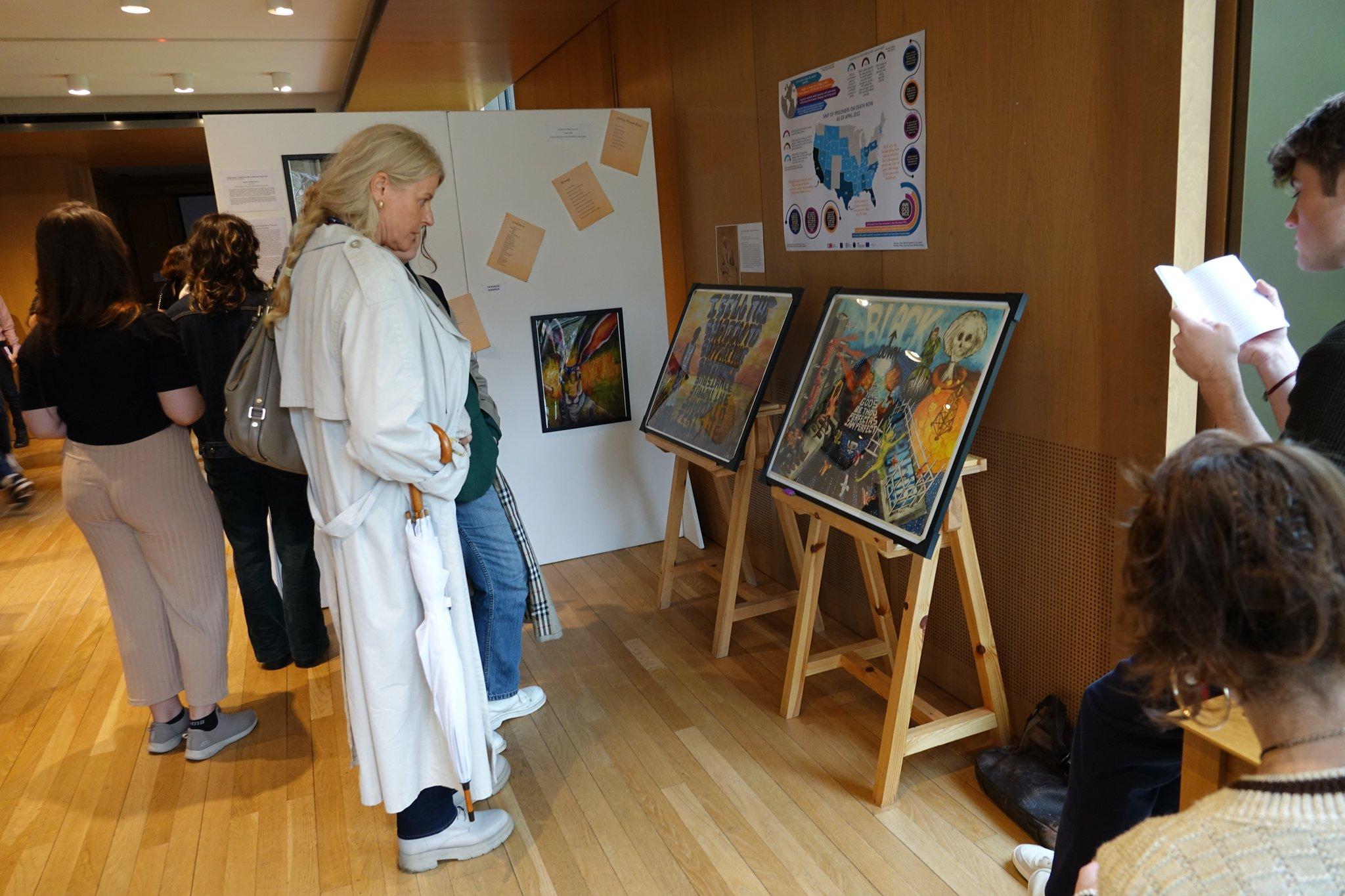 An attendee viewing paintings at the 'Voices from Death Row' exhibition