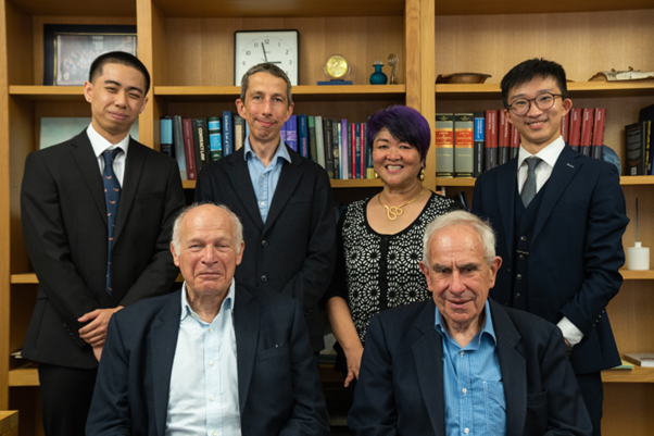 Lords Hoffman and Neuberger, the editors of the OUULJ and the Dean of the Law Faculty in front of a bookcase