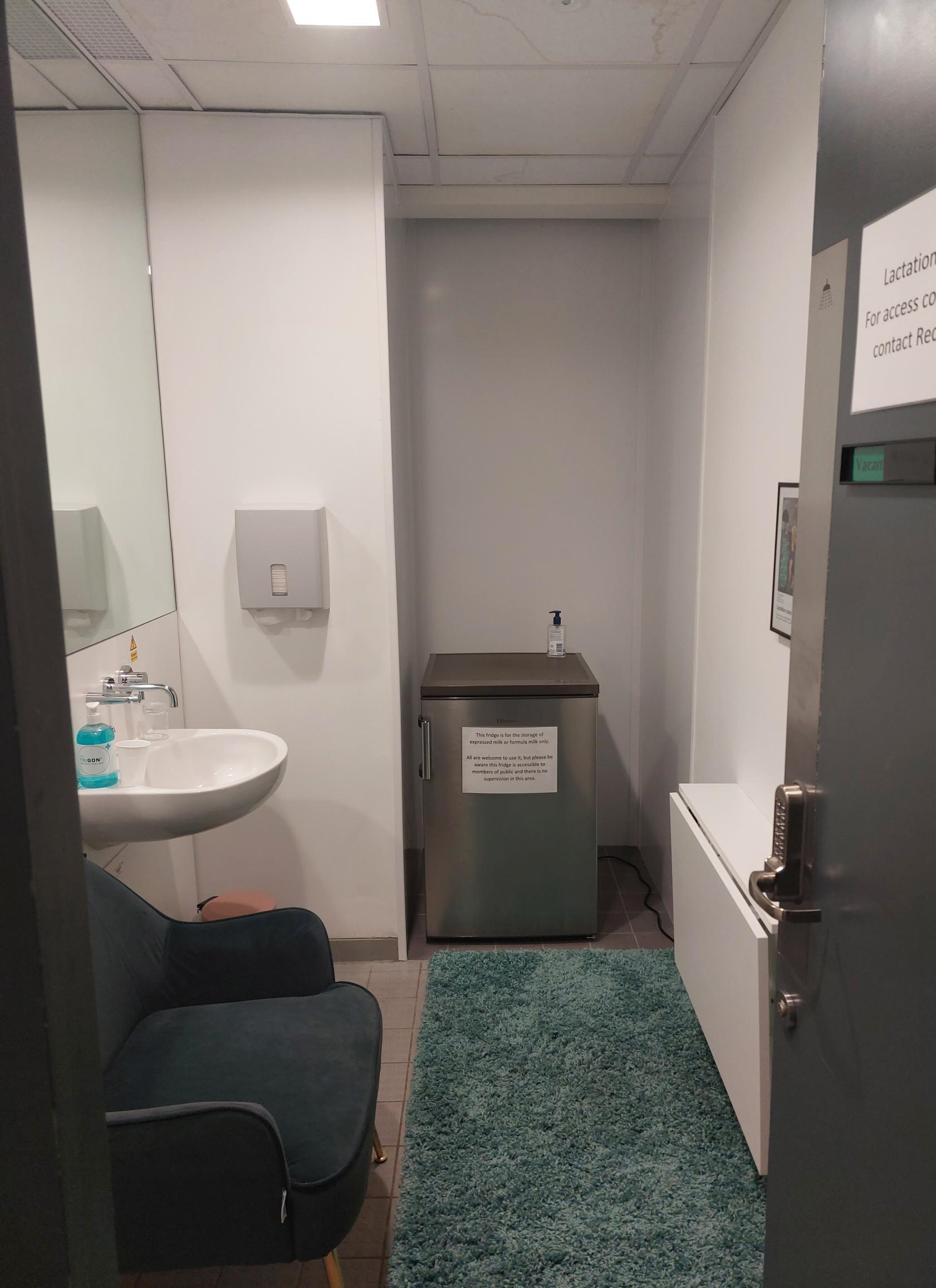 Lactation Room, view from the door: armchair, sink, mini fridge and desk space.