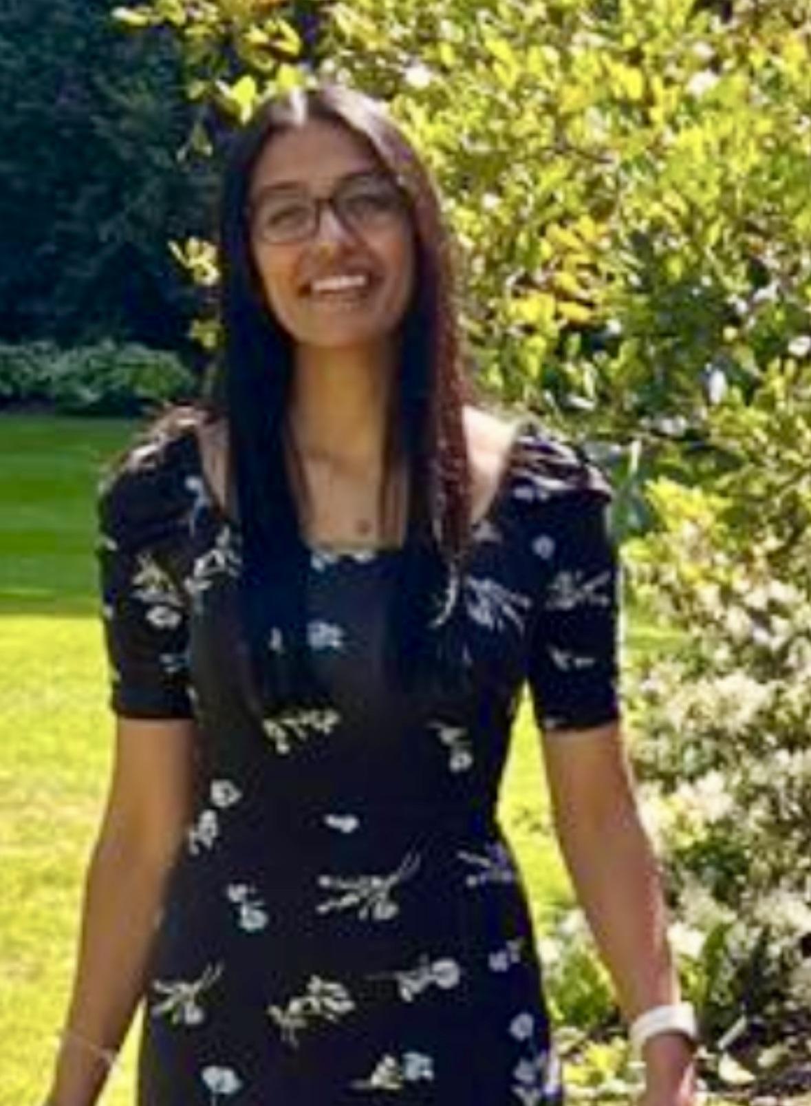 girl with brown hair in a black dress in the sun 