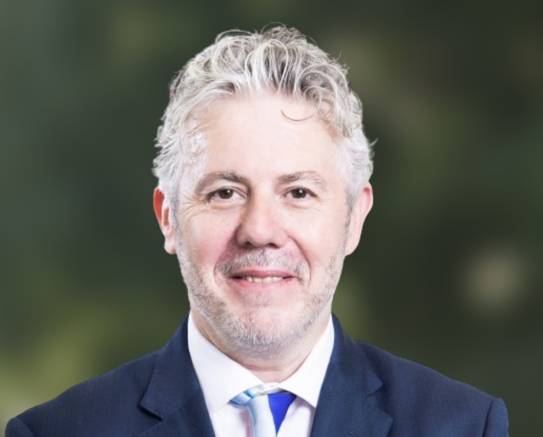 Headshot of Alan Bogg in a formal shirt, tie, and blue blazer.