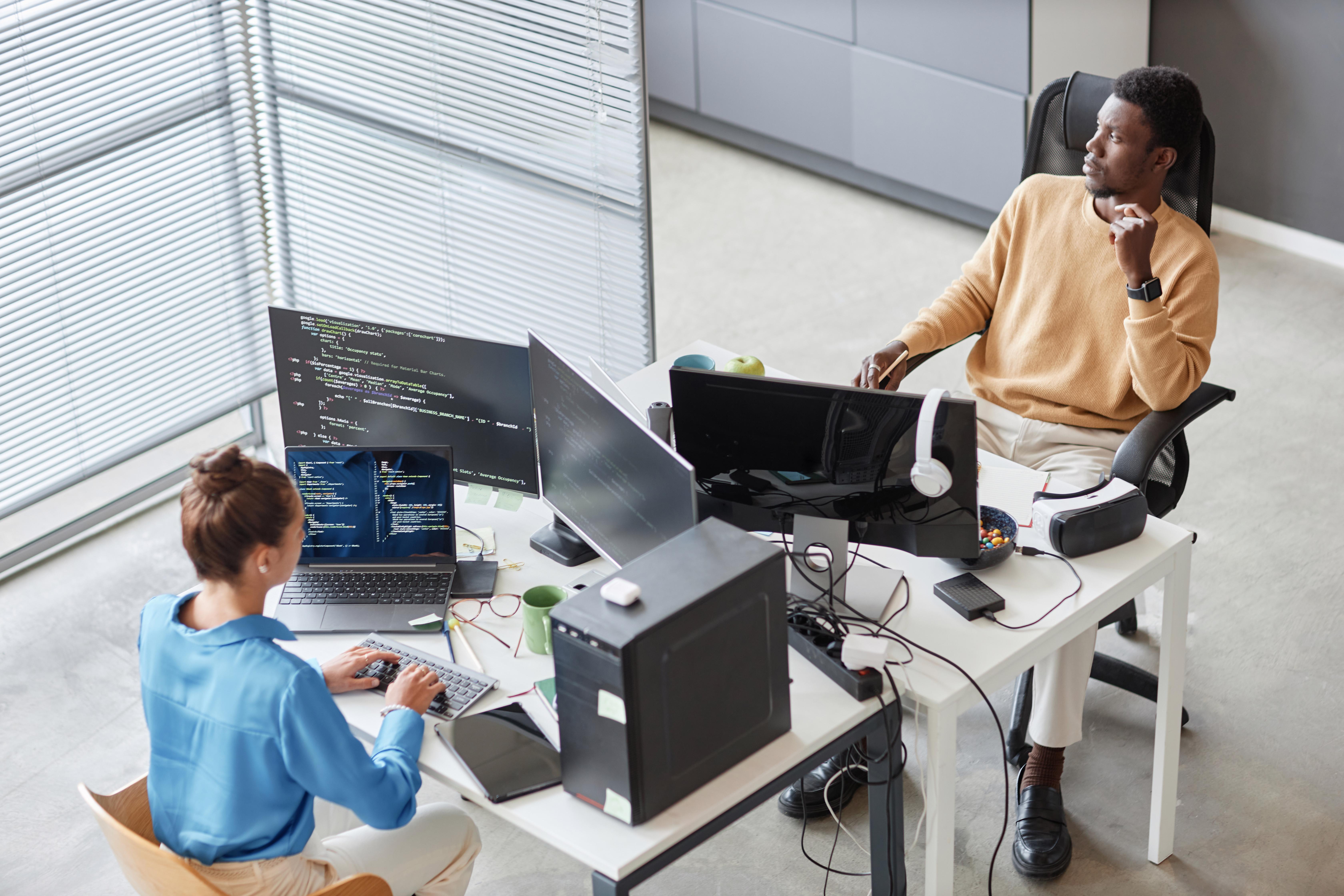 Colleagues writing computer code on computers
