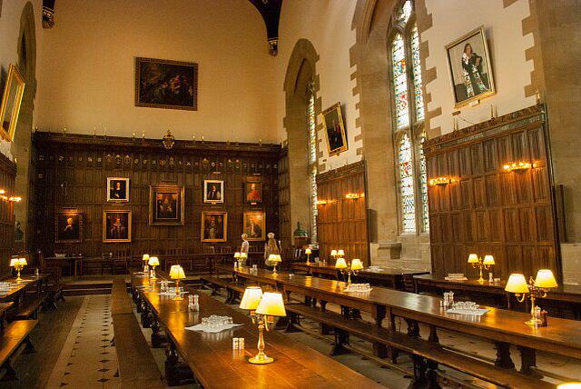 Dining hall at New College. Long tables and benches with lamps at periodic intervals