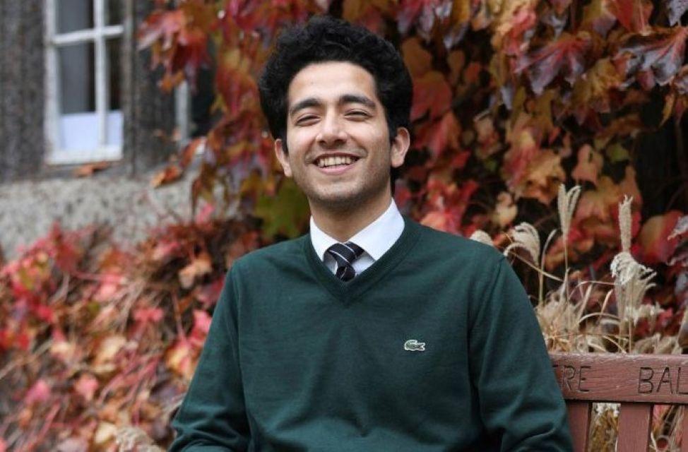 Photo of Aakarsh Banyal sitting outside on a bench looking at the camera