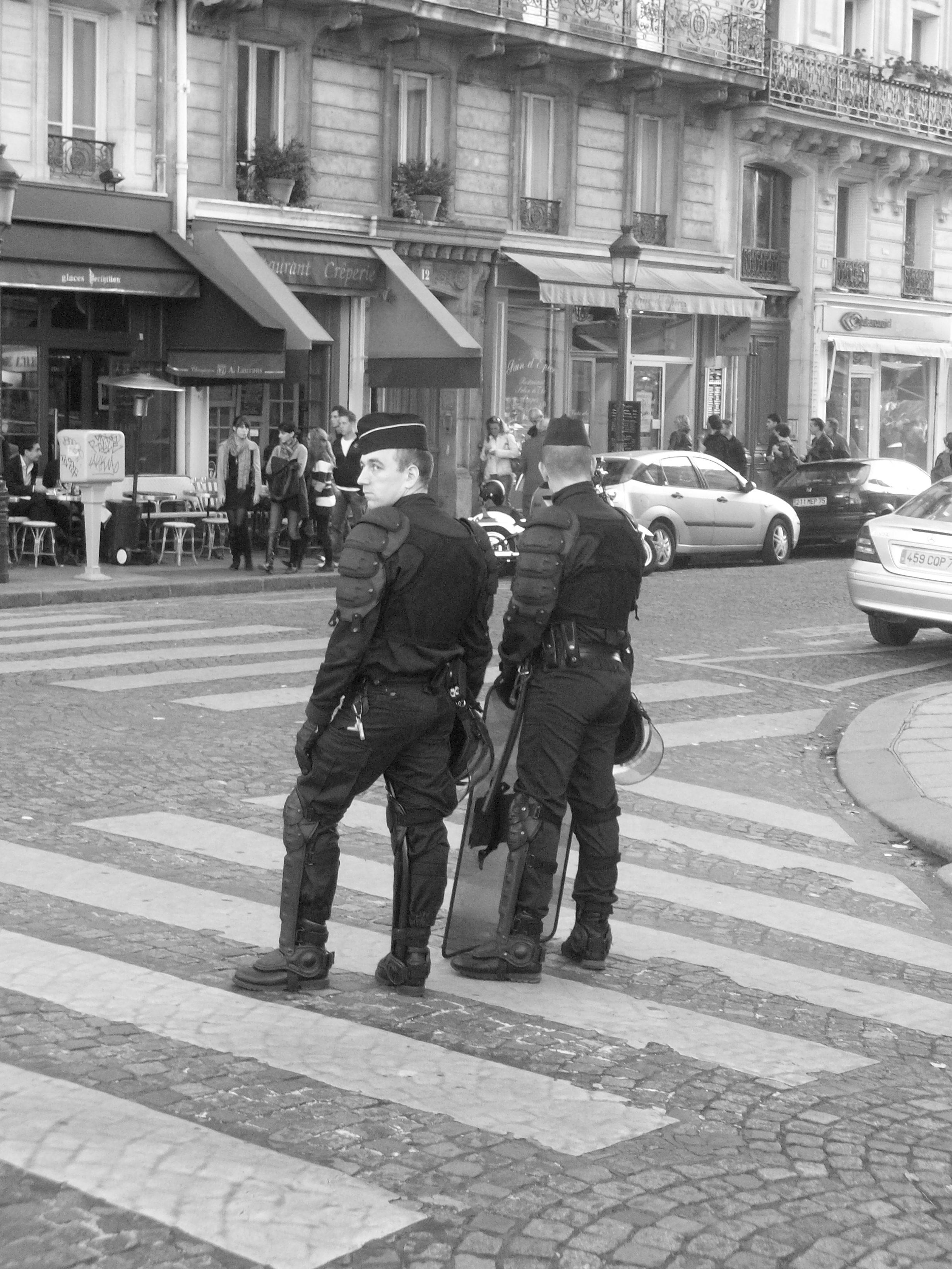 Two police officers stood at the centre of a zebra crossing in the middle of a quiet street.