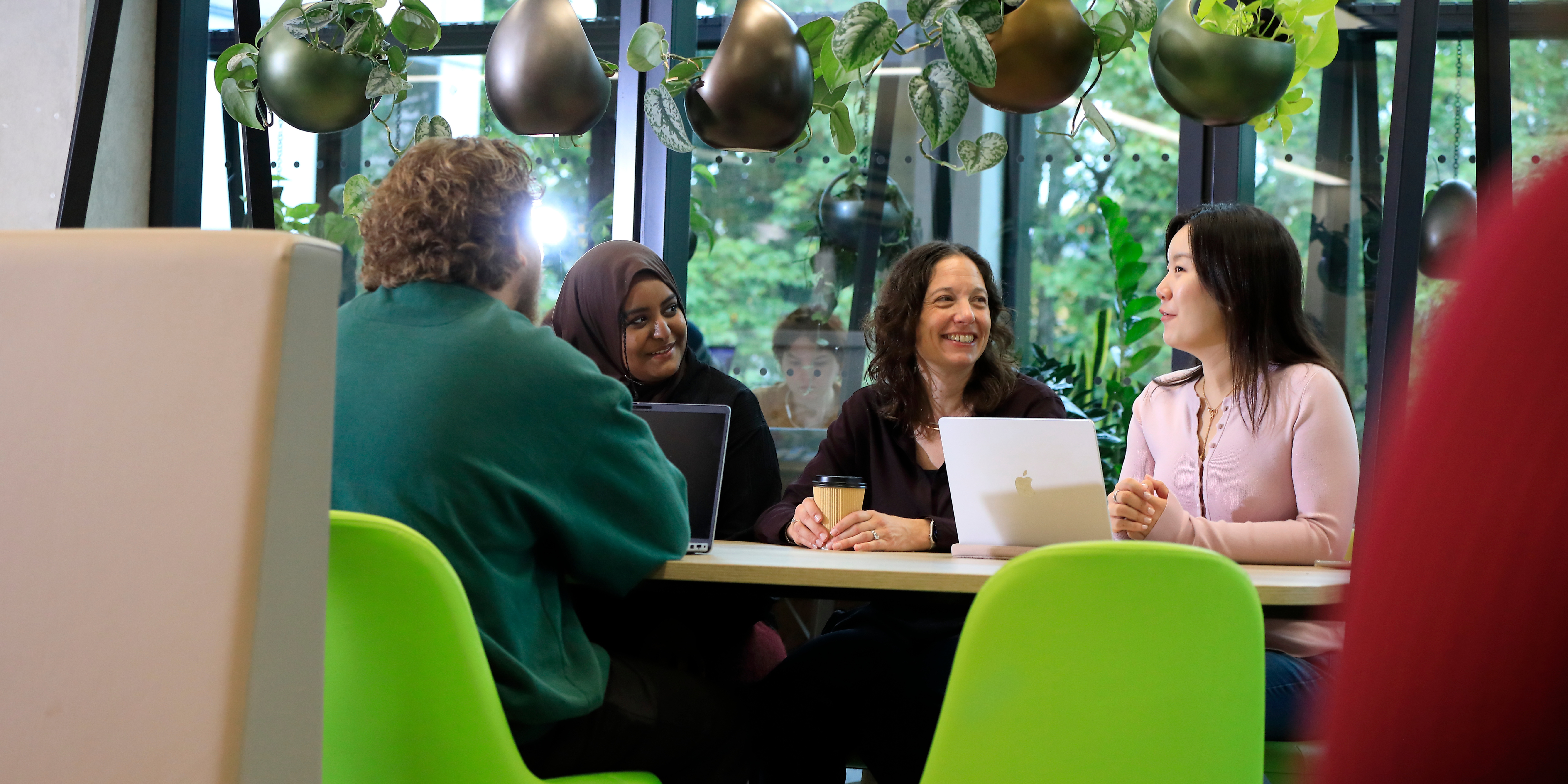 Professor Rebecca Williams talking to a group of students in a modern cafe