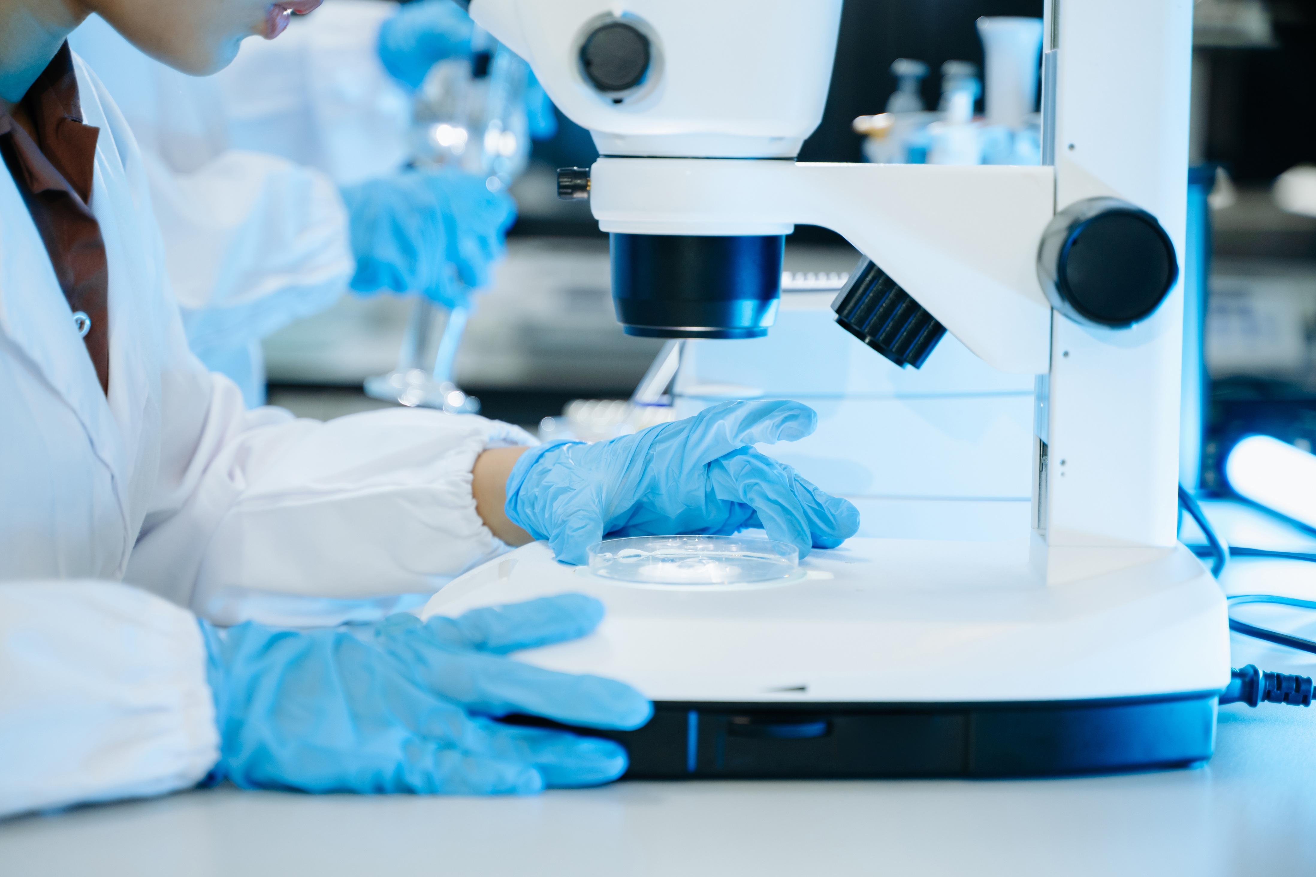 Scientist in laboratory using a microscope.